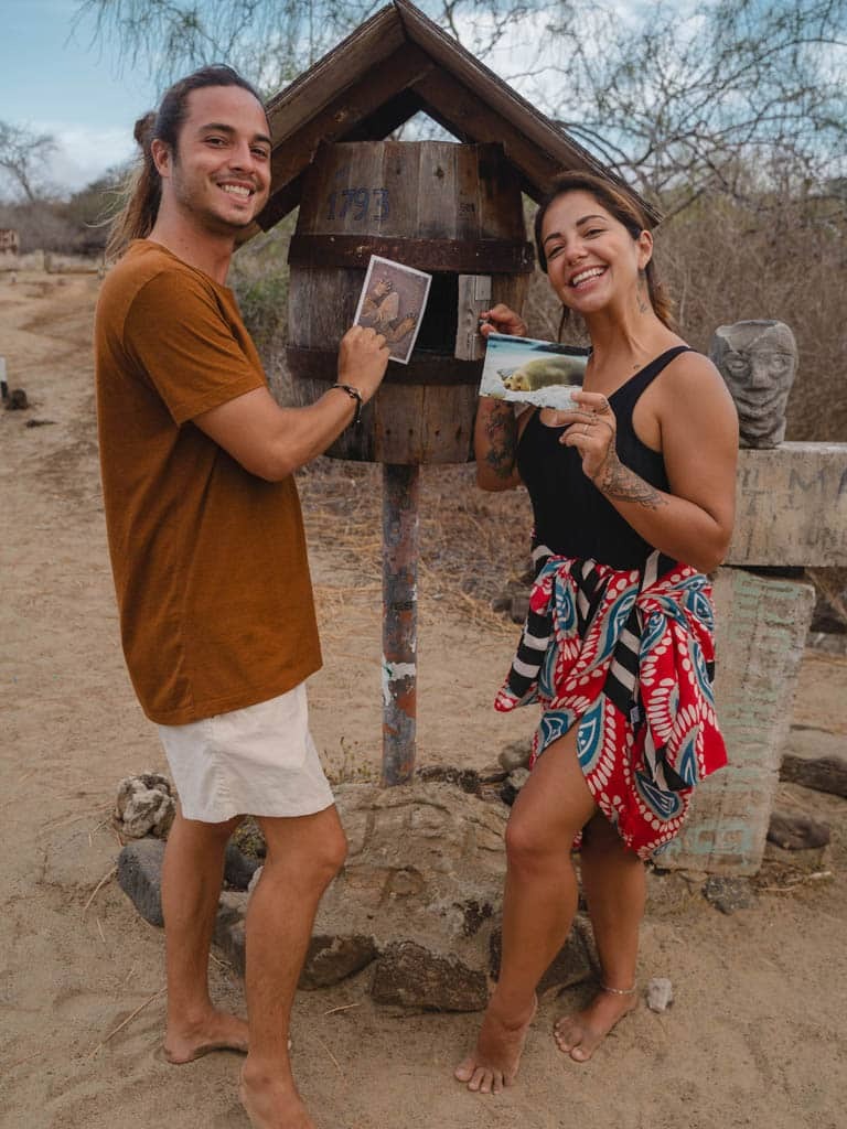 Couple holding postcards at mailbox - post office bay - Galapagos Islands in a Glimpse - Golden Galapagos Cruises
